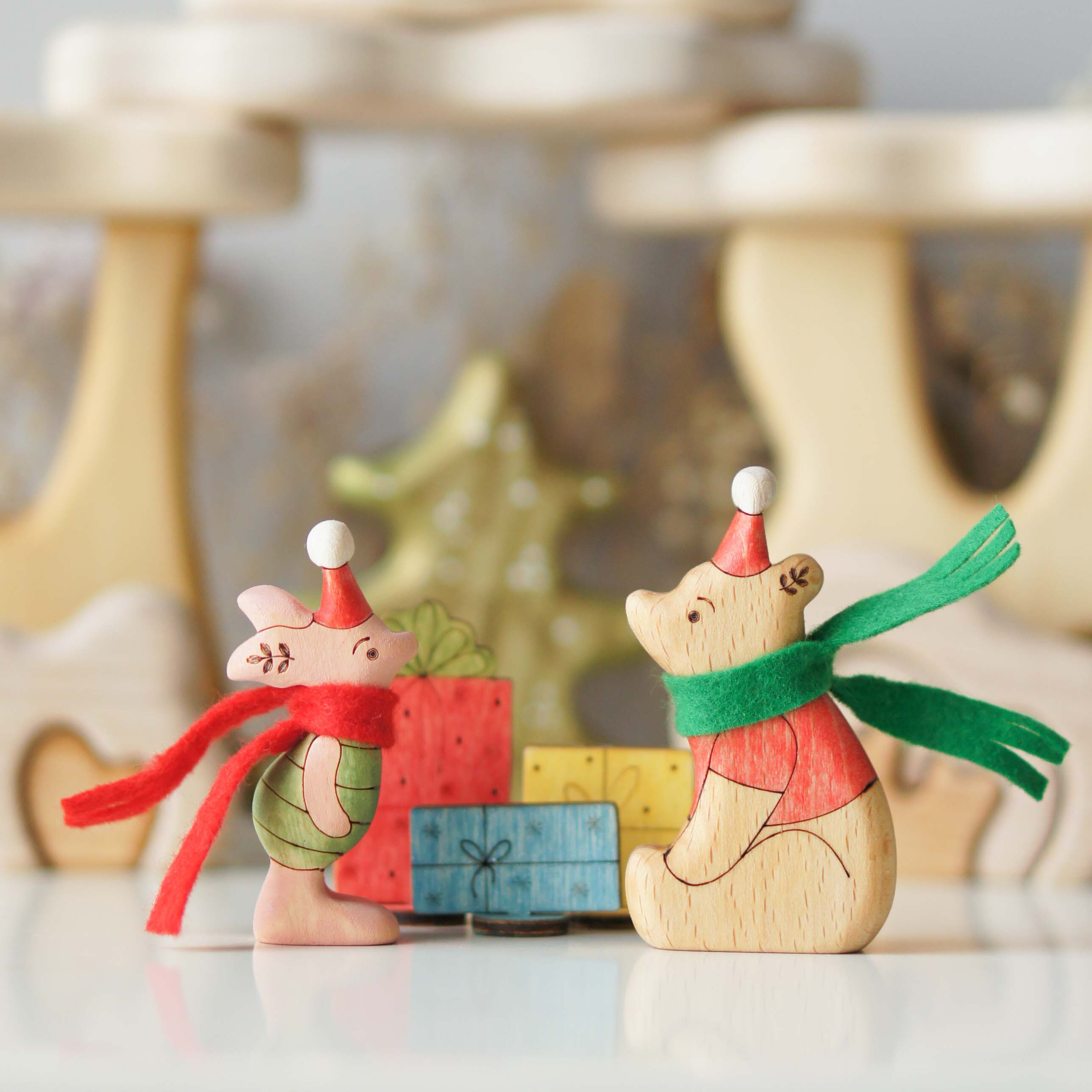Winnie and Piglet in winter scarves beside colourful wooden gifts