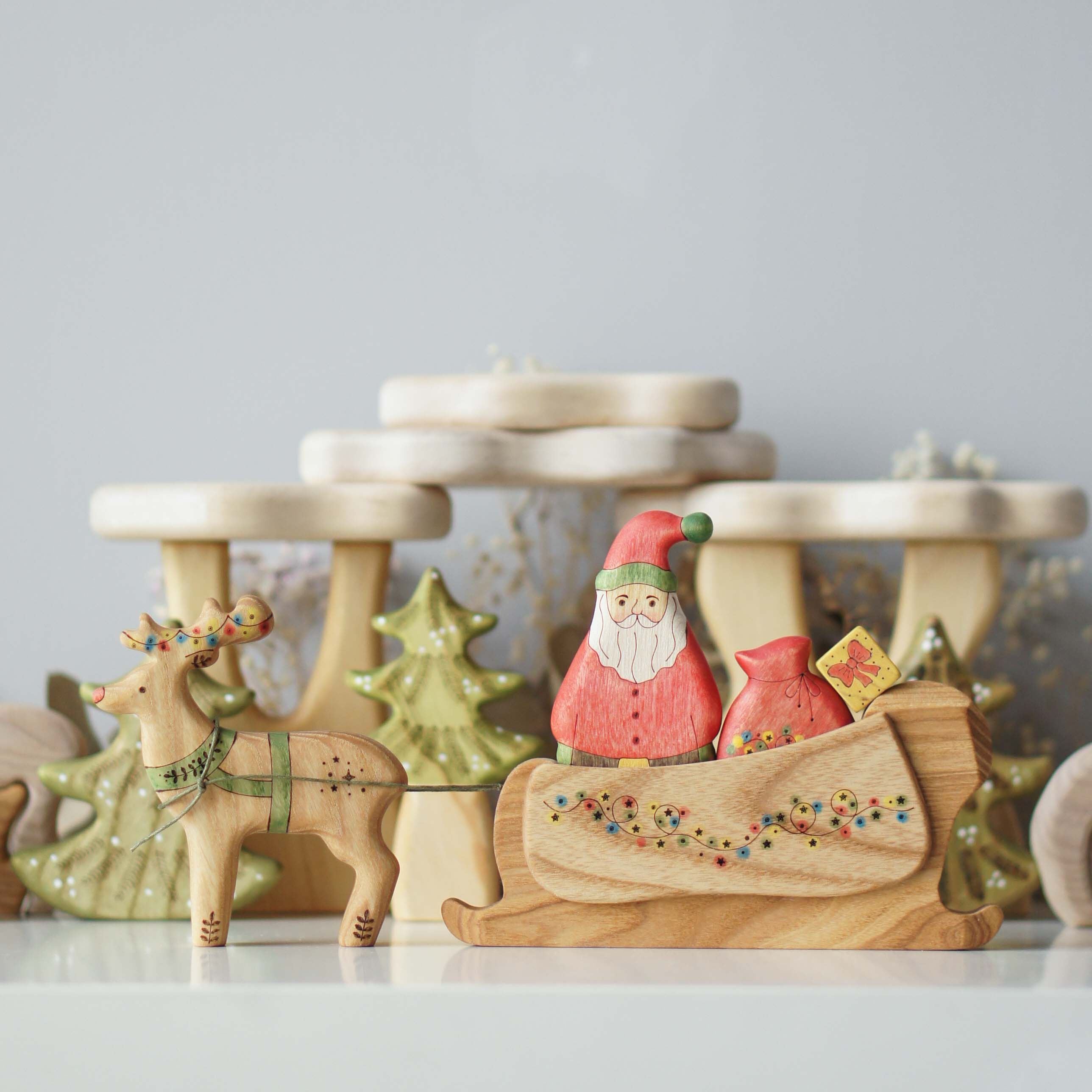 Hand-painted Santa in a wooden sleigh with a reindeer and gifts